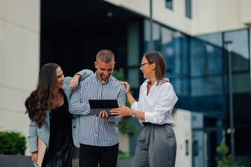 Obraz premium Business people having fun while using digital tablet outdoors