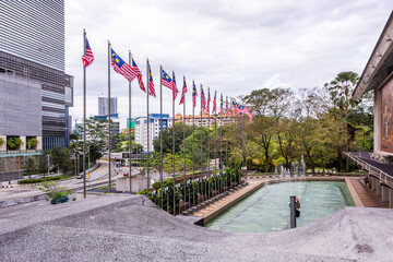 Fountains and Malaysian flags on the street in downtown of Kuala Lumpur, Malaysia