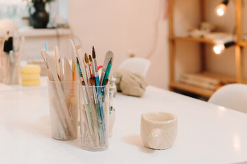 Cozy art studio with sculpting tools. Creative atmosphere for designing ceramic crockery with...