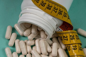 bottle of pills, some of which spilled onto a light blue surface