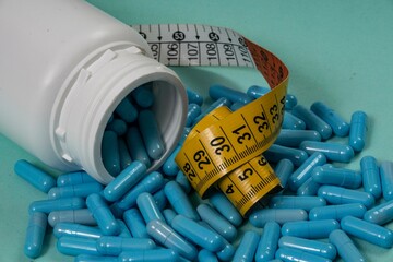 bottle of pills, some of which spilled onto a light blue surface