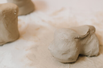 Hands of a female potter making ceramic clay product on the table in the pottery workshop. Potter...