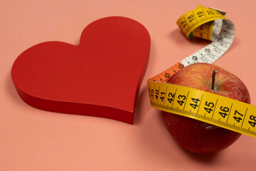 Heart shape with an apple and measuring tape, concept of heart problem and overweight