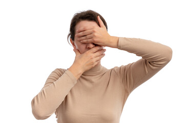 A young woman covering her face with her hands, expressing surprise or shock against a white...
