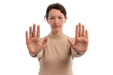 A serious woman in a beige turtleneck holding her hands up against a white background.