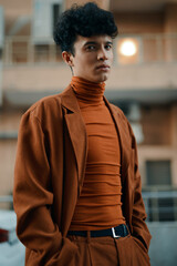 Fototapeta premium Portrait of a young man in a stylish brown outfit, set against an urban backdrop The warm tones create a trendy and modern aesthetic