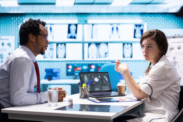 General practitioner consults patient about diagnostic test results, utilizing medical technology...