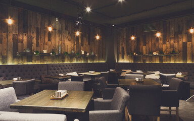 Cozy wooden interior of restaurant, copy space. Comfortable modern dining place, contemporary design background