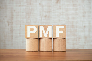 There is wood cube with the word PMF. It is an abbreviation for Product Market Fit as eye-catching...