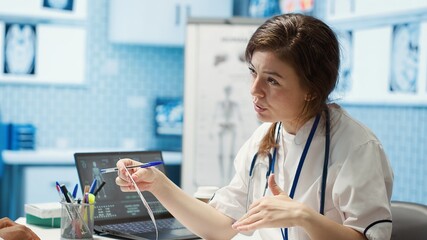 Healthcare professional sharing her medical expertise with a patient in a cabinet, reviewing x ray...