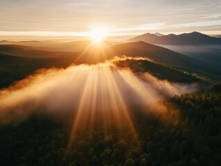 Sunrise over mountains with fog and sun rays