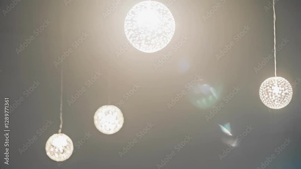 Poster several modern spherical light bulbs are swinging gently, creating a mesmerizing dance of light and 