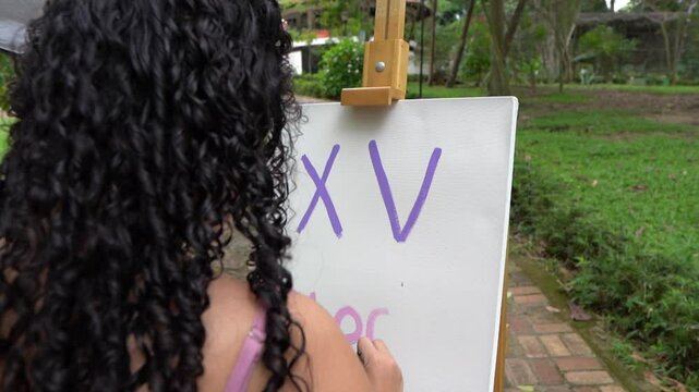 beautiful teenager in dress painting a picture in slow motion