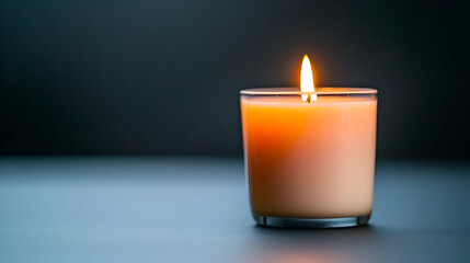 Lit Orange Candle in Glass Jar on Dark Background