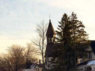 A church steeple with a cross in the afternoon sunlight