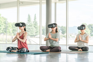 VRゴーグルをつけてヨガをする女性（ヨガ教室）
