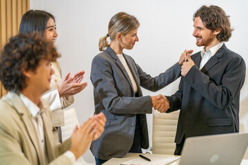 Multiracial team collaborating in modern office, diverse colleagues shaking hands during a business meeting, teamwork success, partnership agreement, professional collaboration multicultural workplace