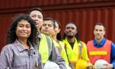 Engineer and worker team working in logistic terminal of container cargo, Diverse construction team in safety gear outdoors