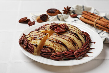 Delicious sweet semolina halva with pecans on white tiled table, closeup