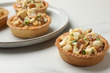 Tartlets with delicious filling on white marble table, closeup