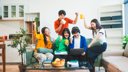 Five young Asian students engage in online study on campus, collaborating on research, projects....