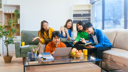 Five young Asian students engage in online study on campus, collaborating on research, projects. They help each other with assignments, gaining valuable experience and preparing for future careers.