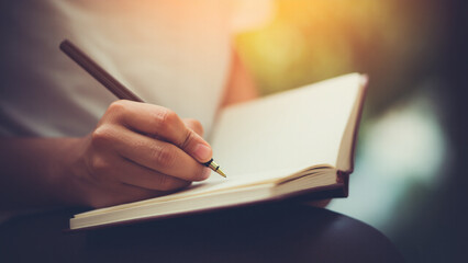 A person holding a journal and writing, symbolizing mindfulness and personal reflection