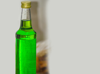 a bottle of melon-flavored green syrup in a glass bottle. an object with copy space for text