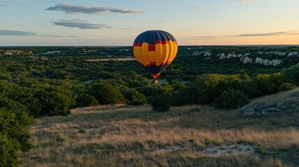 Obraz premium Vibrant Hot Air Balloon Floating Over Scenic Landscape During Golden Hour Sunset