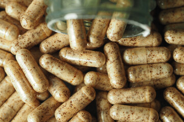 Natural dietary supplements in capsules scattered on a surface