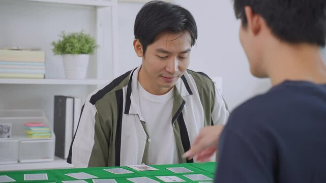 Asian young men poker players playing casino card game together in house. 