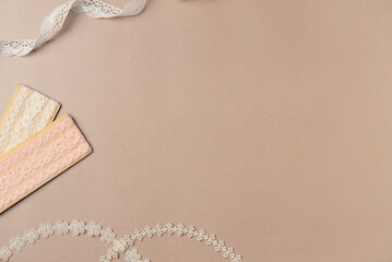 Sewing accessories on beige background. Different tapes. Flat lay, top view. Copy space