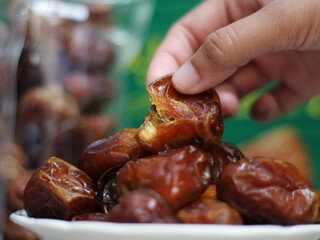 Close-up of Hand Taking Dates from a Bowl