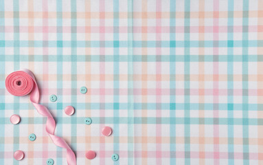 Buttons and ribbon on a fabric background. Flat lay, top view. Copy space