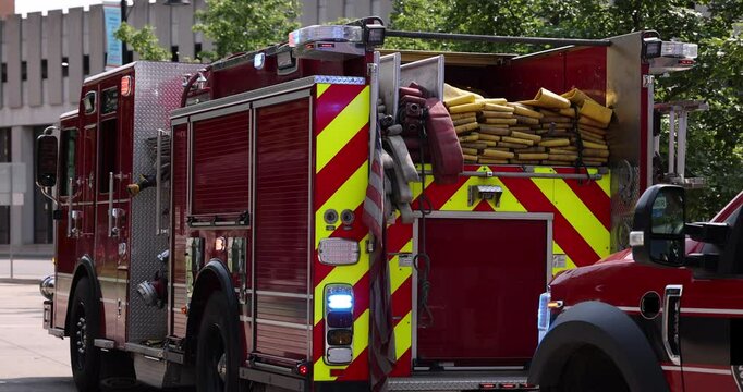 An ambulance and fire engine respond to an emergency on a city street with lights and sirens.