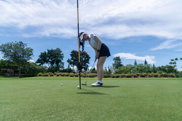 Obraz premium Professional woman golfer teeing golf in golf tournament competition at golf course for winner