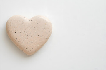 Fototapeta premium heart shaped rock with soft pink and beige tones, perfect for decoration or gifts. Its smooth surface and unique texture add touch of elegance to any setting