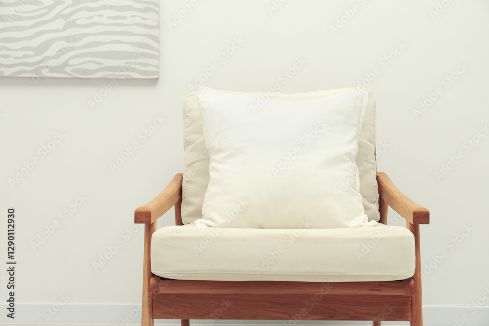 Sticker Blank soft pillow on cozy armchair near light grey wall indoors