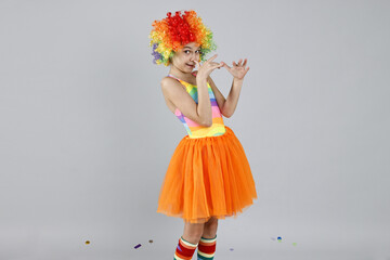 Cute girl dressed like clown on grey background, space for text. Surprise party