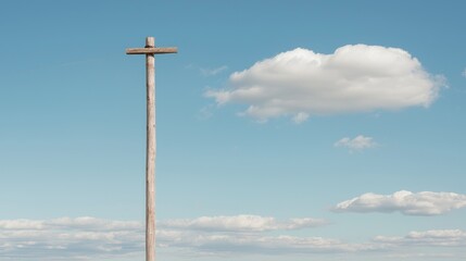 Wooden utility pole under a blue sky with clouds; rural landscape