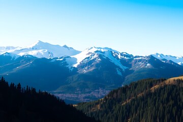 Fototapeta premium A picturesque view of a snowy mountain range with an untouched valley below
