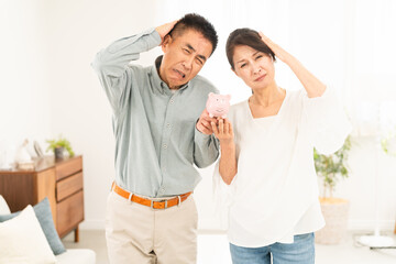 豚の貯金箱を持つ熟年夫婦