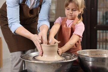 Hobby and craft. Daughter with her mother making pottery indoors, closeup