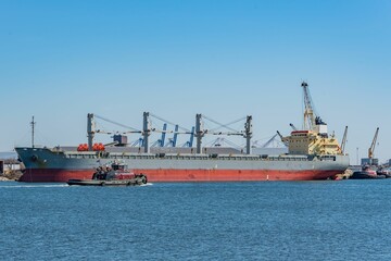 Fototapeta premium Tugboats Near an Ocean Going Vessel, Port of Baltimore Maryland