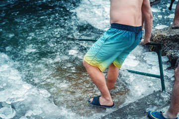 Winter swimming. Man in an ice-hole.