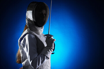 Fencer with epee on dark blue background, space for text