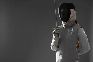 Fencer with epee on gray background, space for text