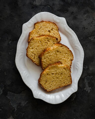 Slices of ricotta lemon cake on a white plate on a dark background