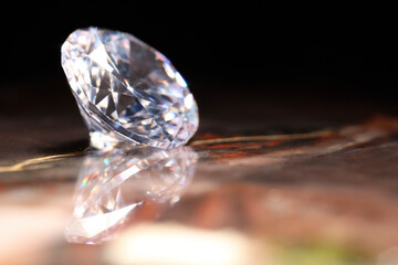 Beautiful shiny gemstone on brown marble surface against dark background, closeup. Space for text