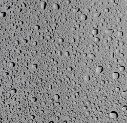 Water drops on grey glass surface, top view
